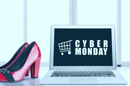 Cyber Monday - Computer with shoes next to it