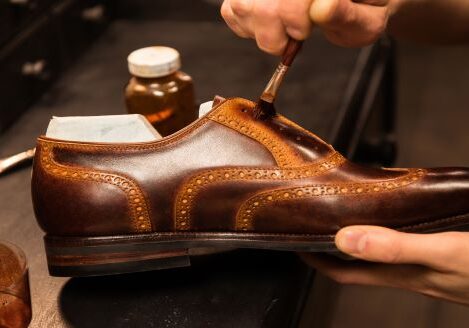 brown shoe being brushed by hand